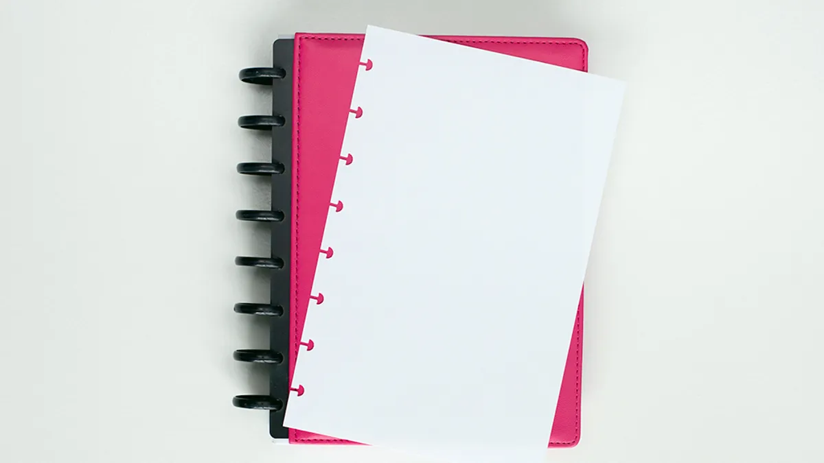 Disc bound notebook with pages clipped onto a row of discs