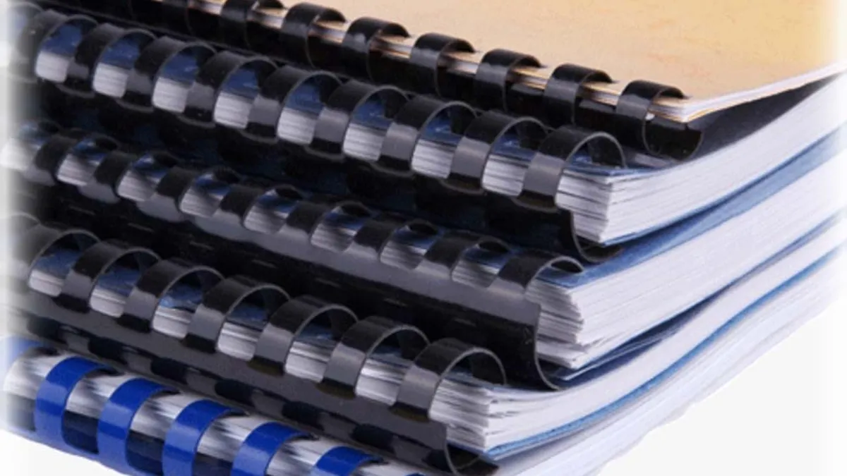 Plastic comb binding with curved teeth threaded through punched slots along the spine